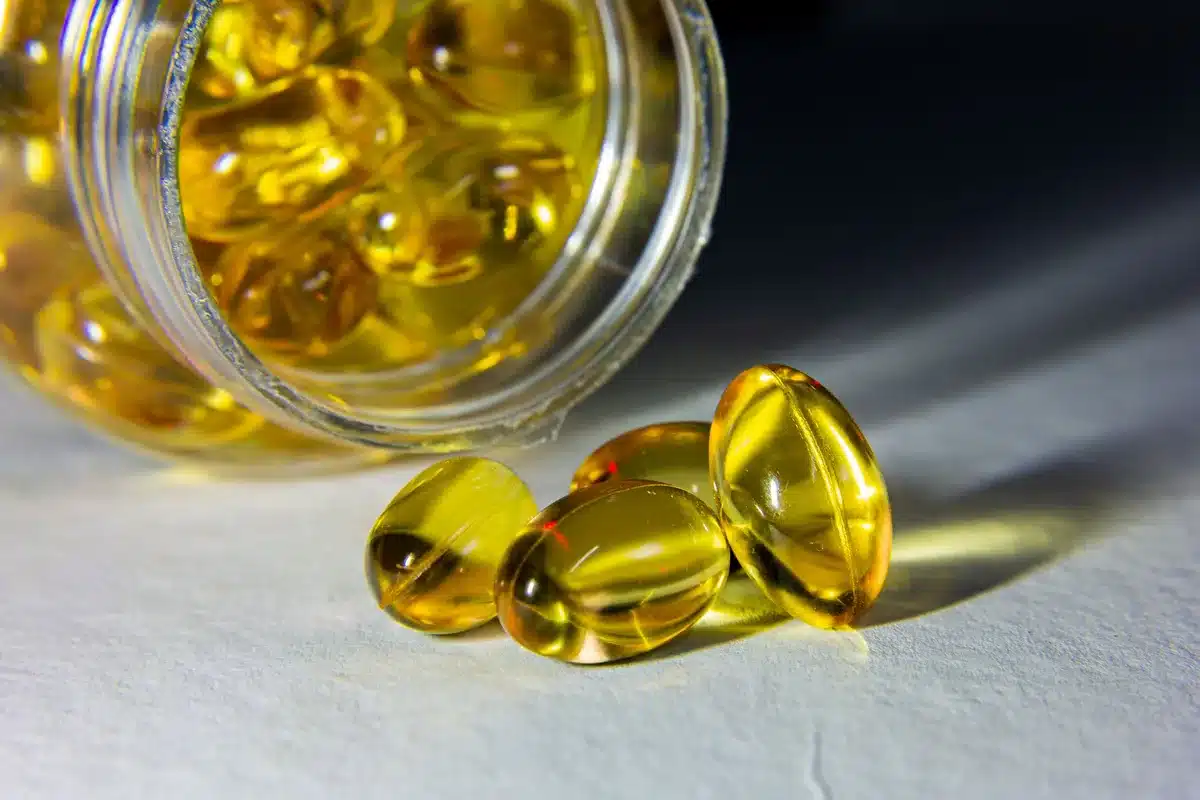 Gélules et comprimés de vitamine D alignés, symbolisant la supplémentation contre la carence saisonnière