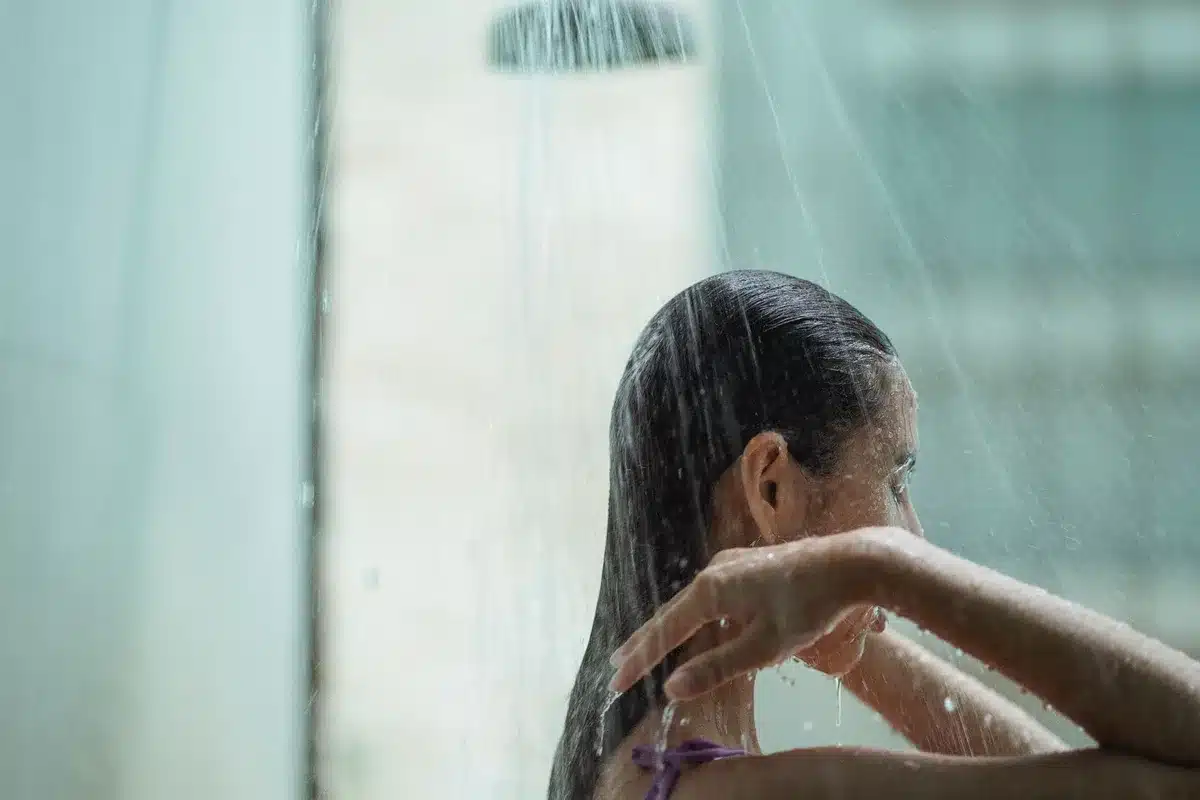 Femme prenant une douche avec de l'eau tiède, soins de la peau