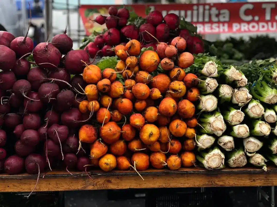 Étal de marché avec asperges, petits pois, épinards et légumes racines au printemps