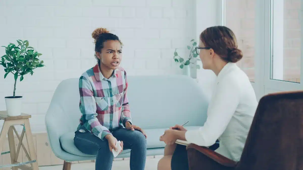 Deux personnes en conversation calme, l'une écoutant attentivement l'autre, symbolisant le soutien et l'écoute bienveill
