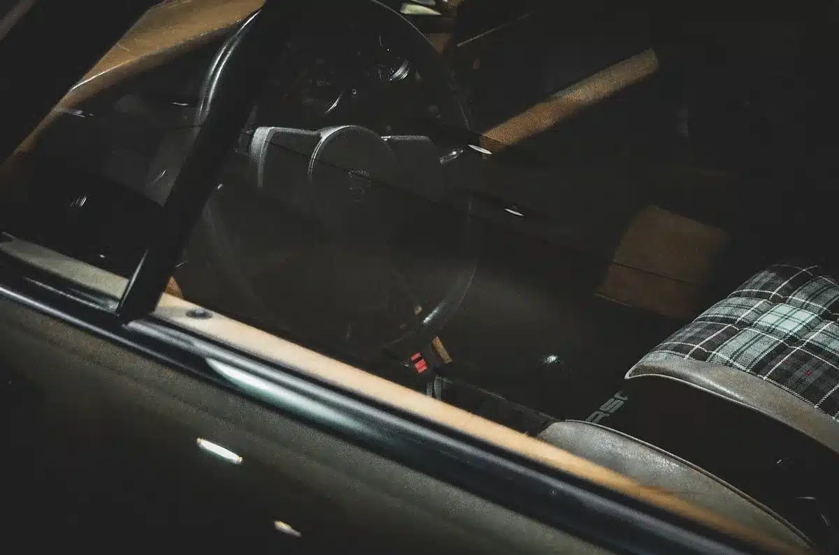 Mains installant un coussin lombaire entre dossier et bas du dos dans une voiture