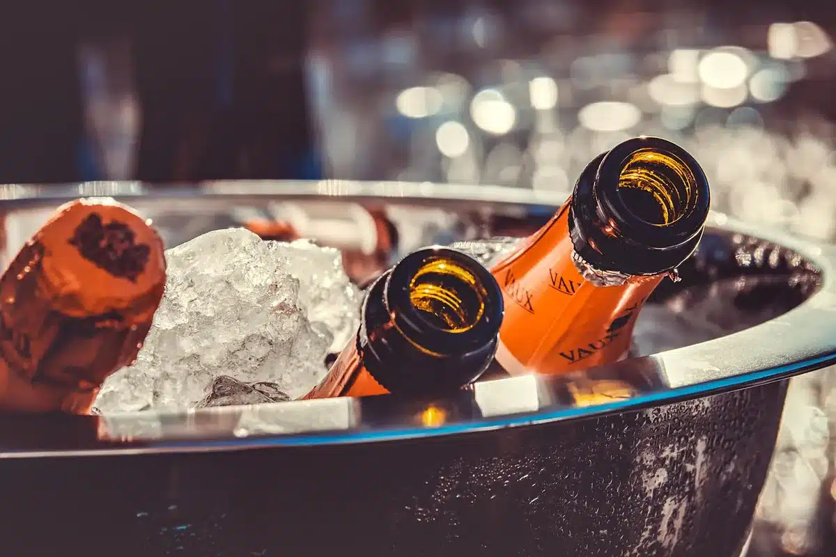 Mains montrant la technique d'ouverture d'une bouteille de champagne refroidie
