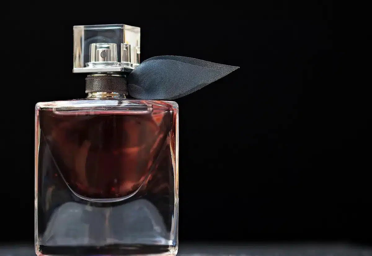 Verre d'eau avec un petit flacon de complément et une cuillère à mesurer